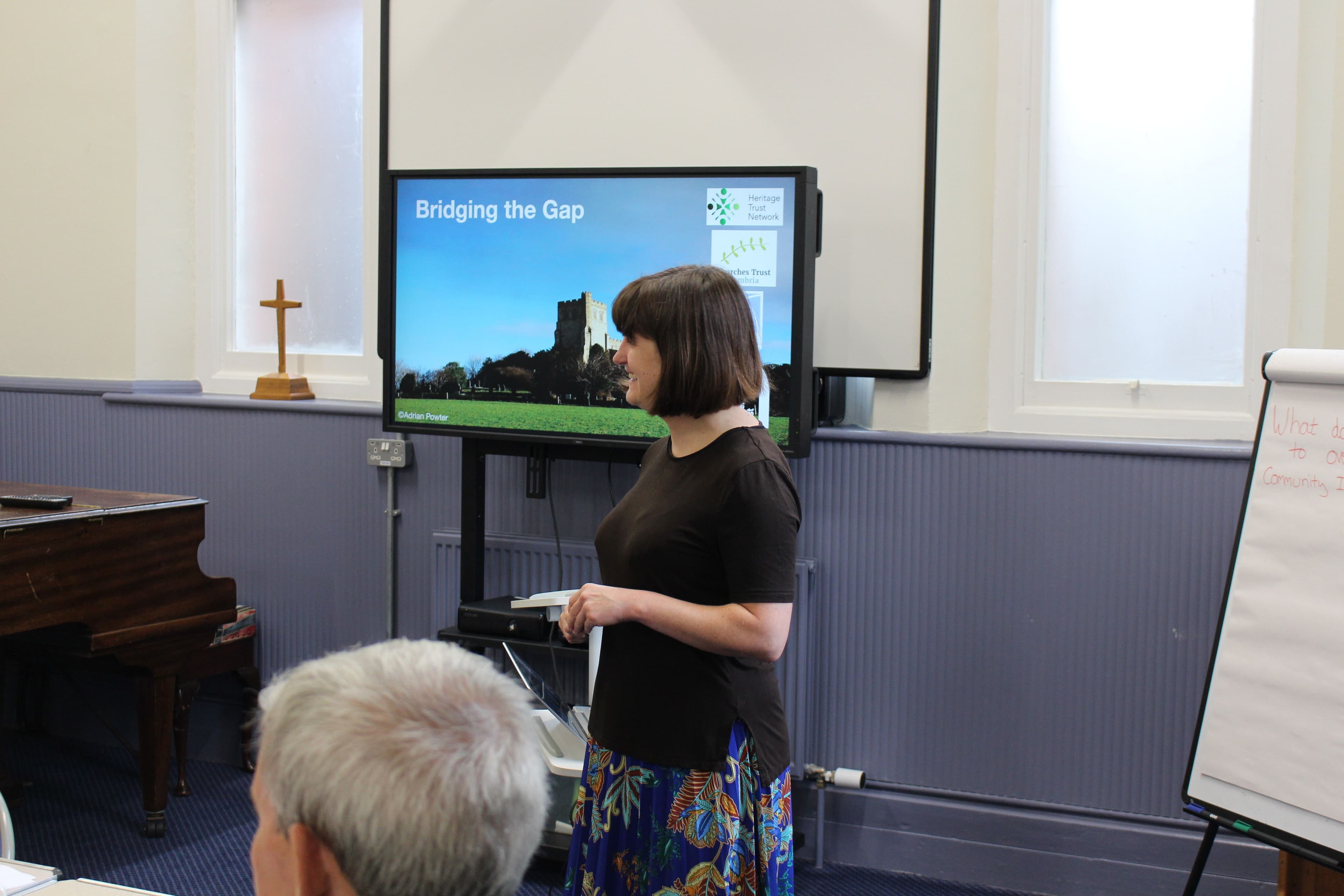 A woman presenting at a 'Bridging the Gap' event.