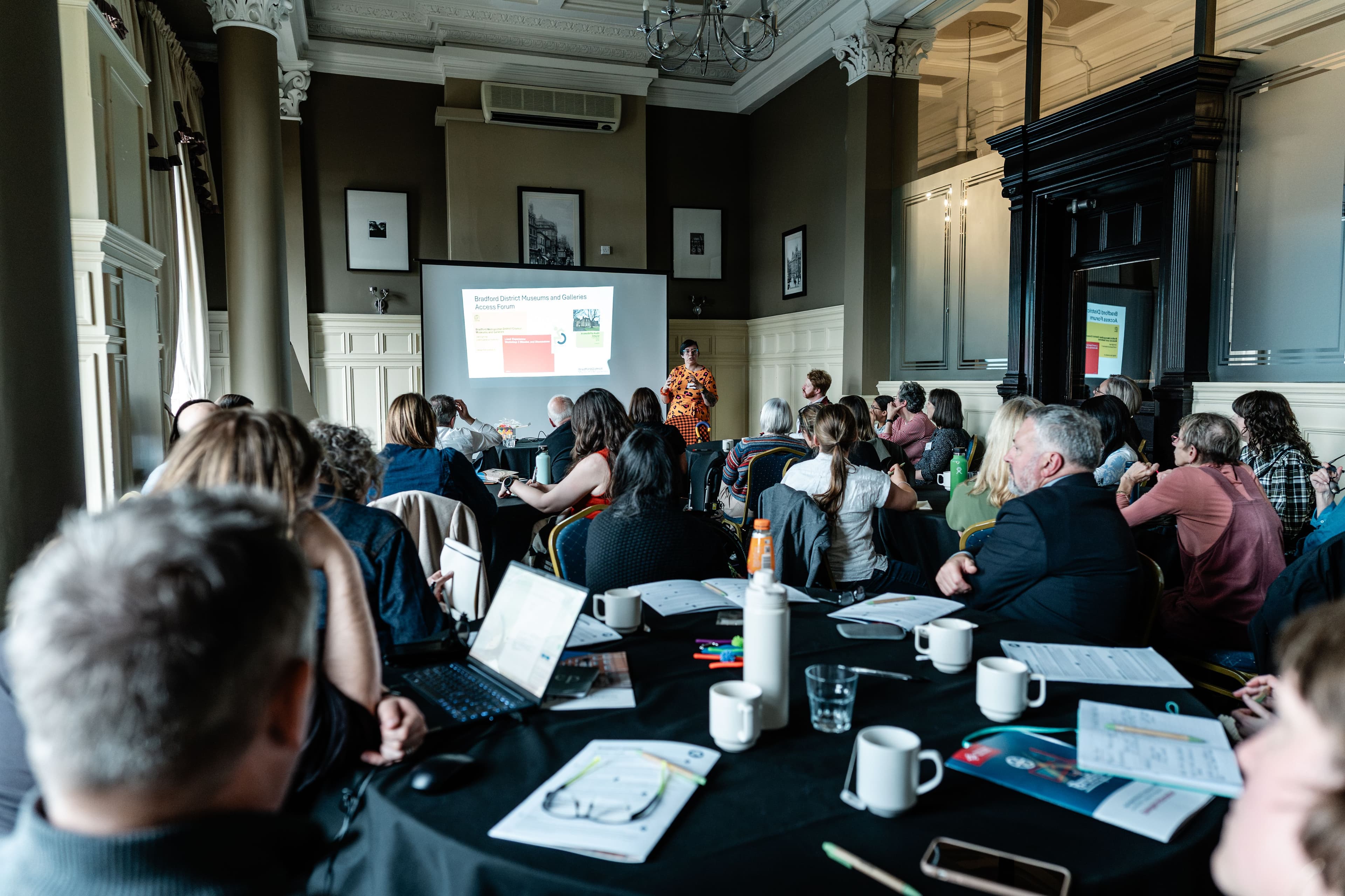 A group of people watching a powerpoint presentation at the Heritage Network 2025 conference